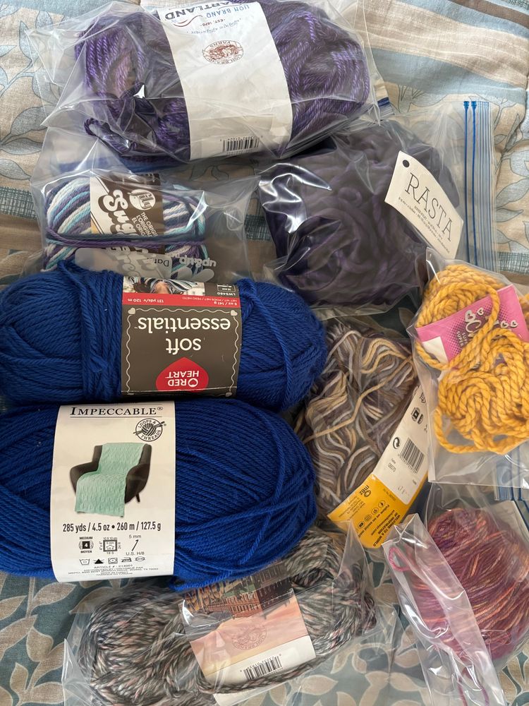 Nine partial skeins of yarn. I have no idea how much of each is there. Labels in included in these. One of the blues might be new actually. The small white/blue/purple near the top left too. And the Malabrigo Arroyo (maroon/yellow) in the bottom right is probably close to a full one. 