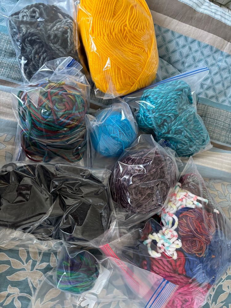 Eight partial skeins of yarn and one bag of odds and ends. I have no idea how much of each is there. These don't have labels but the bright blue in the middle is Malabrigo Arroyo. 