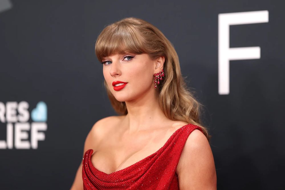 Taylor Swift wearing a red dress, red lipstick and red earrings at the 2025 Grammy awards 