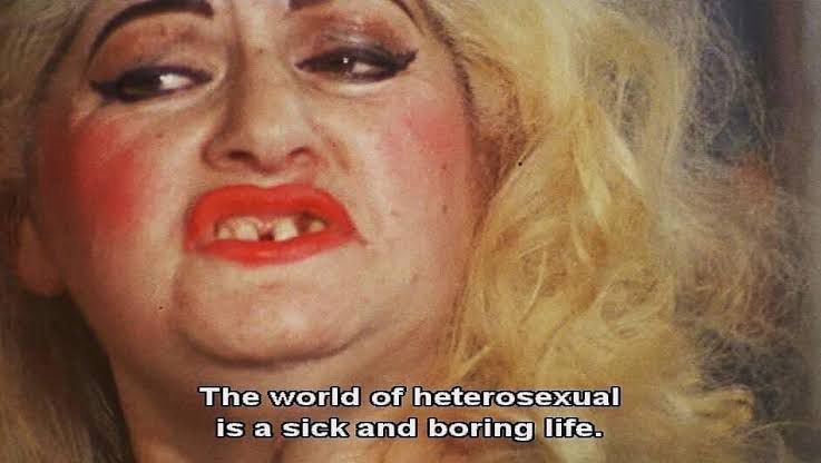 Edith Massey looking gorgeous with the words The world of heterosexual is a sick and boring life.