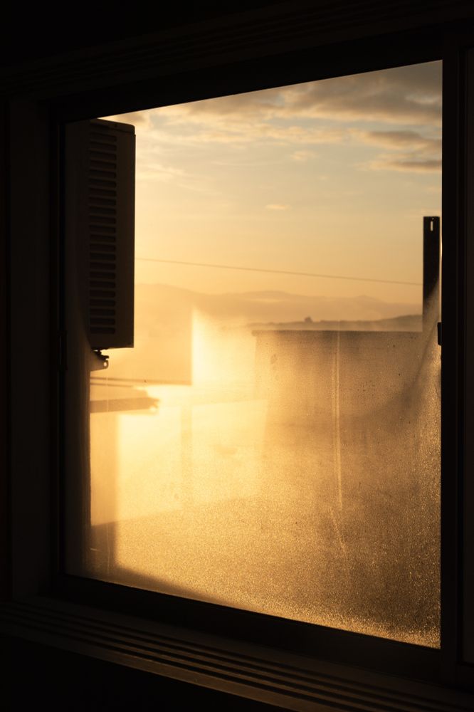 窓の結露が朝日で照らされている写真