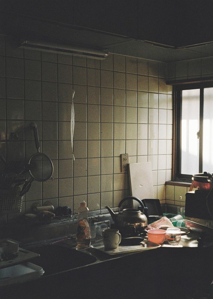 台所の写真。シンクの横にトレイやカップなどが散乱している