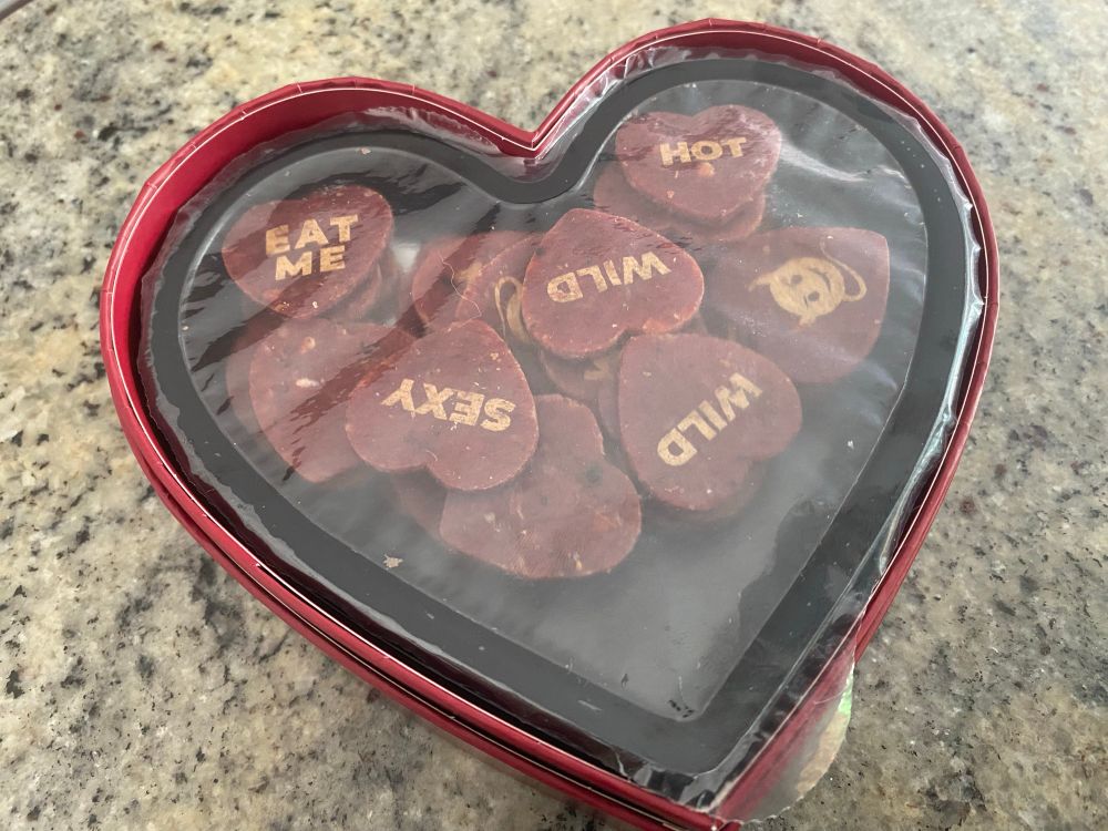 Picture of Naughty Meat Hearts, beef jerky in the shape of a heart with words like “love” and “sexy”, similar to candy hearts but made of meat. 