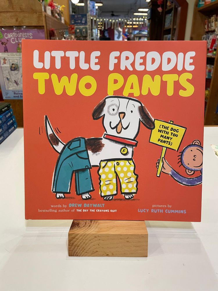 Cover of Little Freddie Two Pants by Drew Daywalt and Lucy Ruth Cummins. A black a white dog wears a pair of pants on its front legs and a pair on its back legs. 
