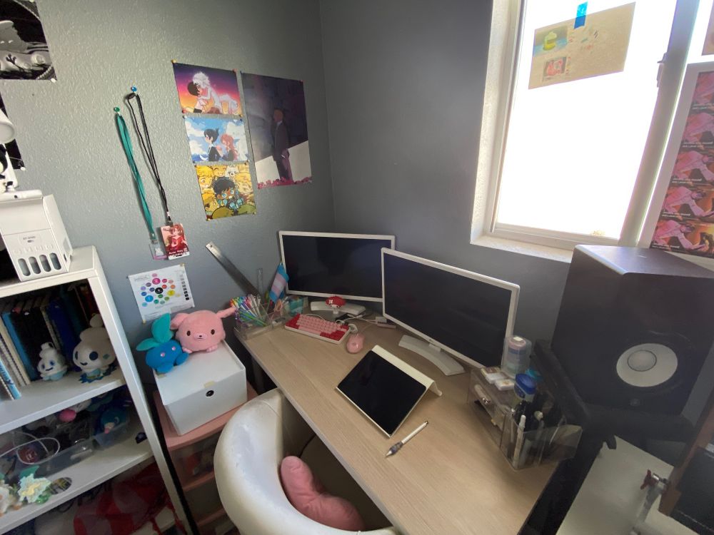 close up of the desk. the prints are Evangelion and CSM (AkiAngel) by Gendakiwi. A dungeon meshi print (KabruLai) by Joylichi and a print of Naoki Urasawa’s Pluto by Jeluto