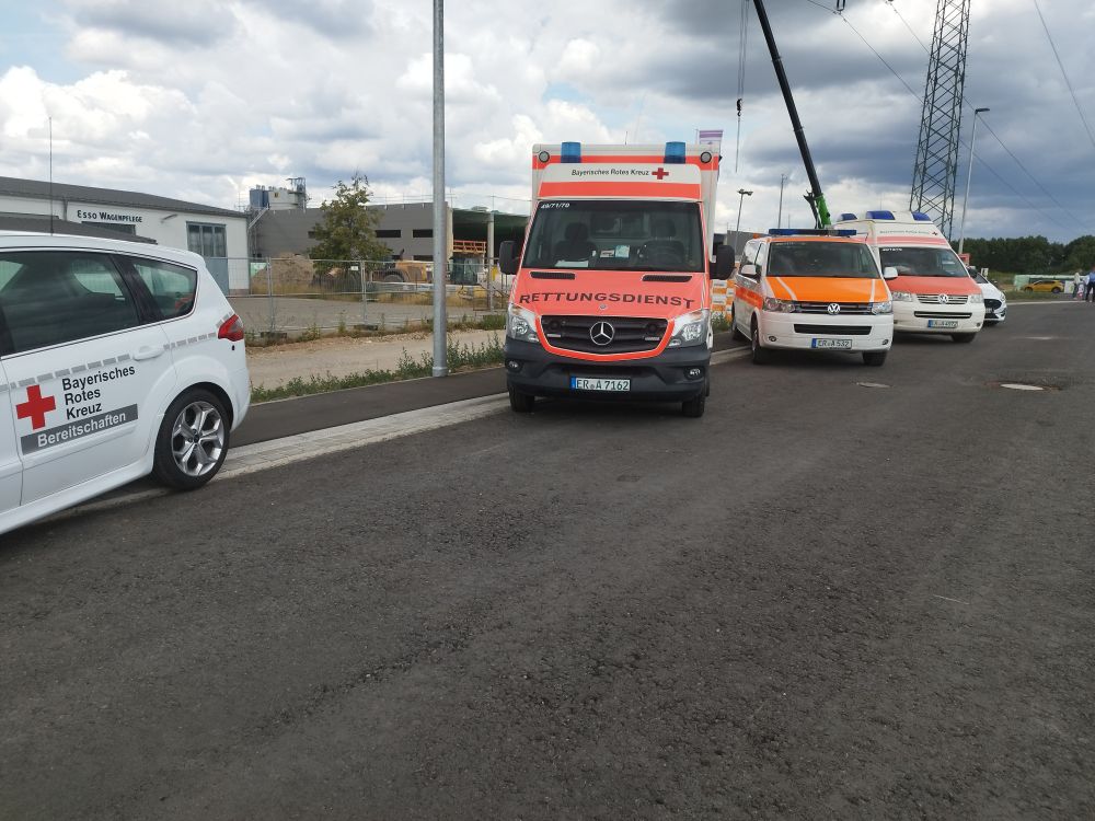 Verschiedene Einsatzfahrzeuge des BRK stehen aufgereiht nebeneinander am Straßenrand
