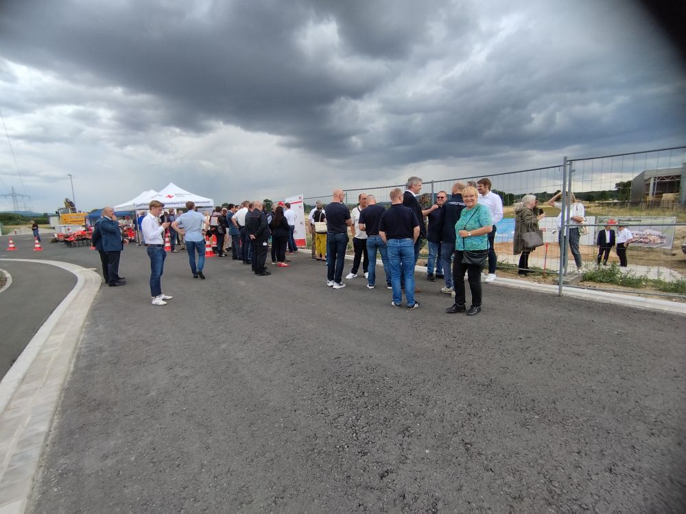 Viele geladene Gäste stehen vor zwei Pavillons des BRK auf der Baustelle der künftigen Rettungswache 