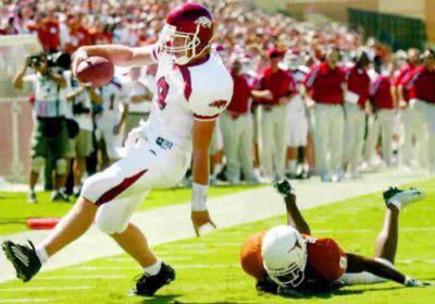 Matt Jones throwing horns down as a Texas defender is on the ground behind him
