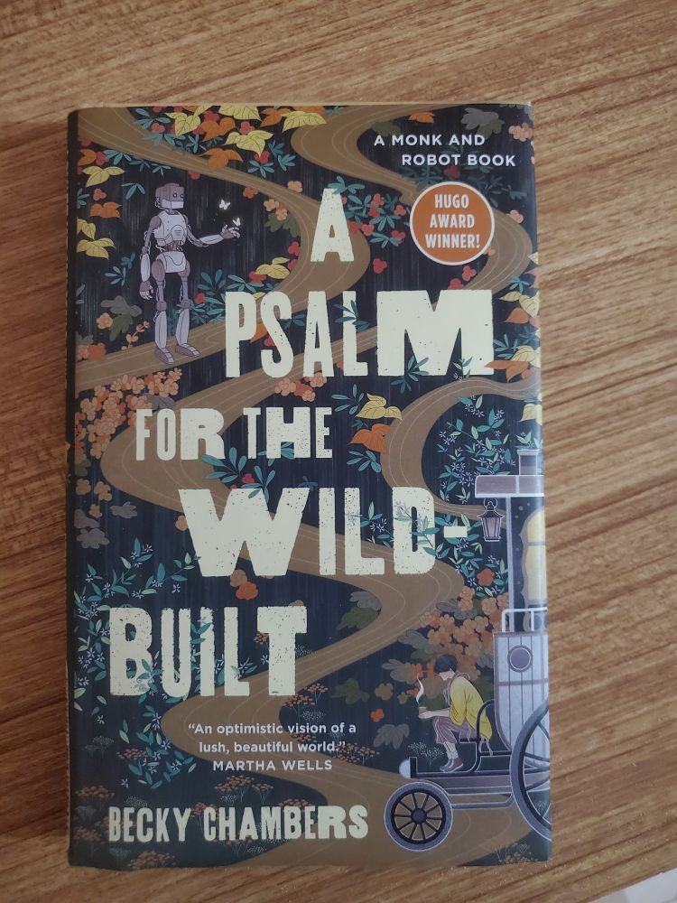 A picture of the book A Psalm for the Wild-Built sitting on a wood table top.