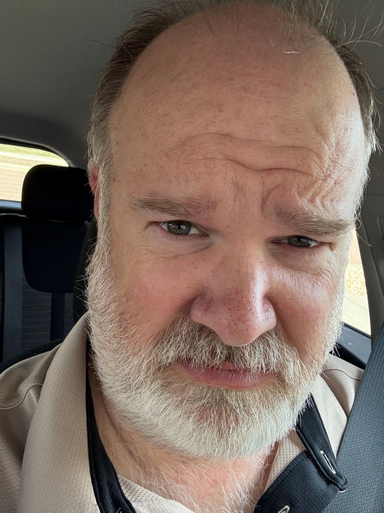 Picture of author with disgusted face looking at man without beard 