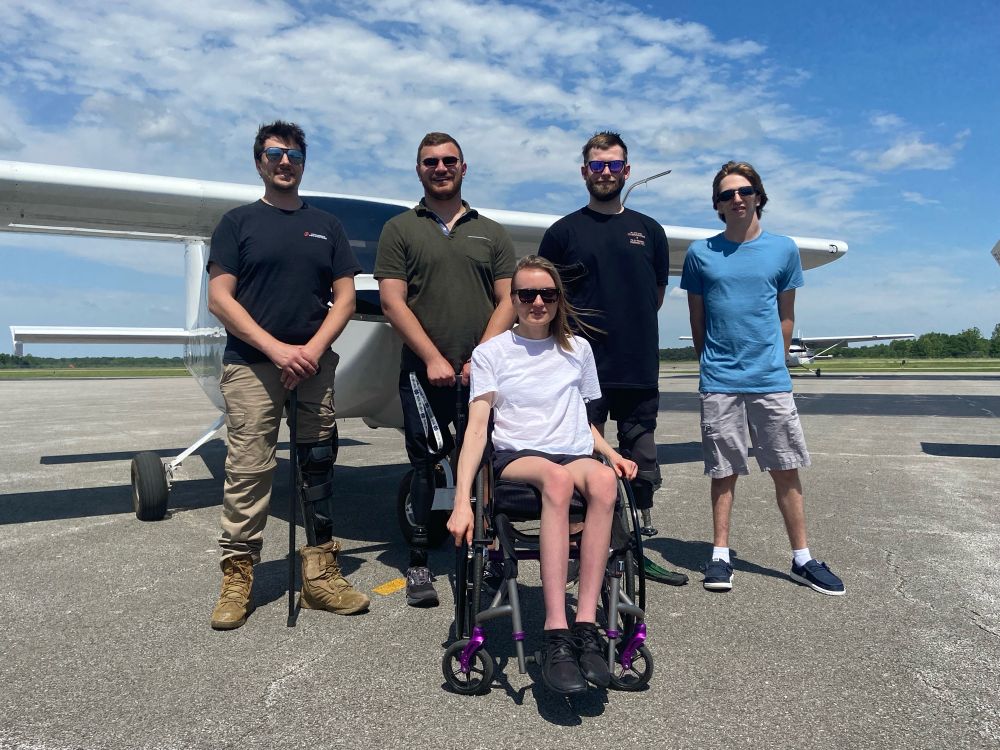 Five people, one woman and four men, are in front of an adapted training airplane at Southern Illinois University in May 2024. They are all recipients of an Able Flight Scholarship for people with physical disabilities to train to become  pilots. They face the challenges of paralysis, amputation or a life long illness, and all five are now licensed pilots. 