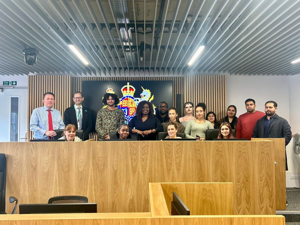 Marsha with students stood behind a long desk