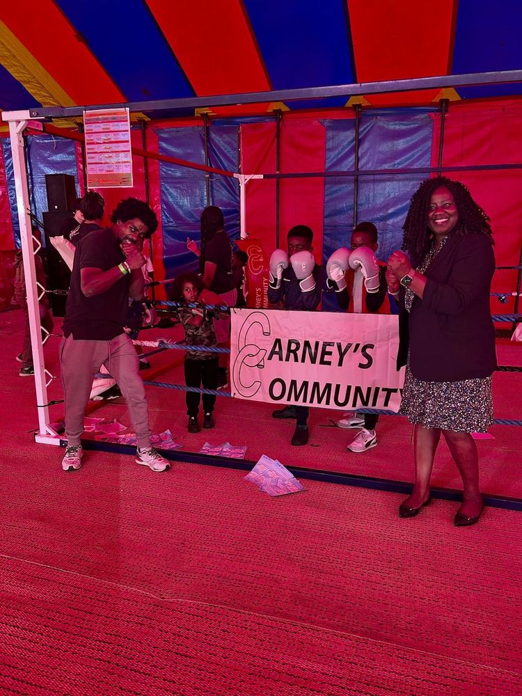 Marsha outside a boxing ring with fists up