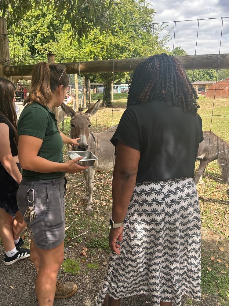 Marsha with zookeeper feeding a donkey