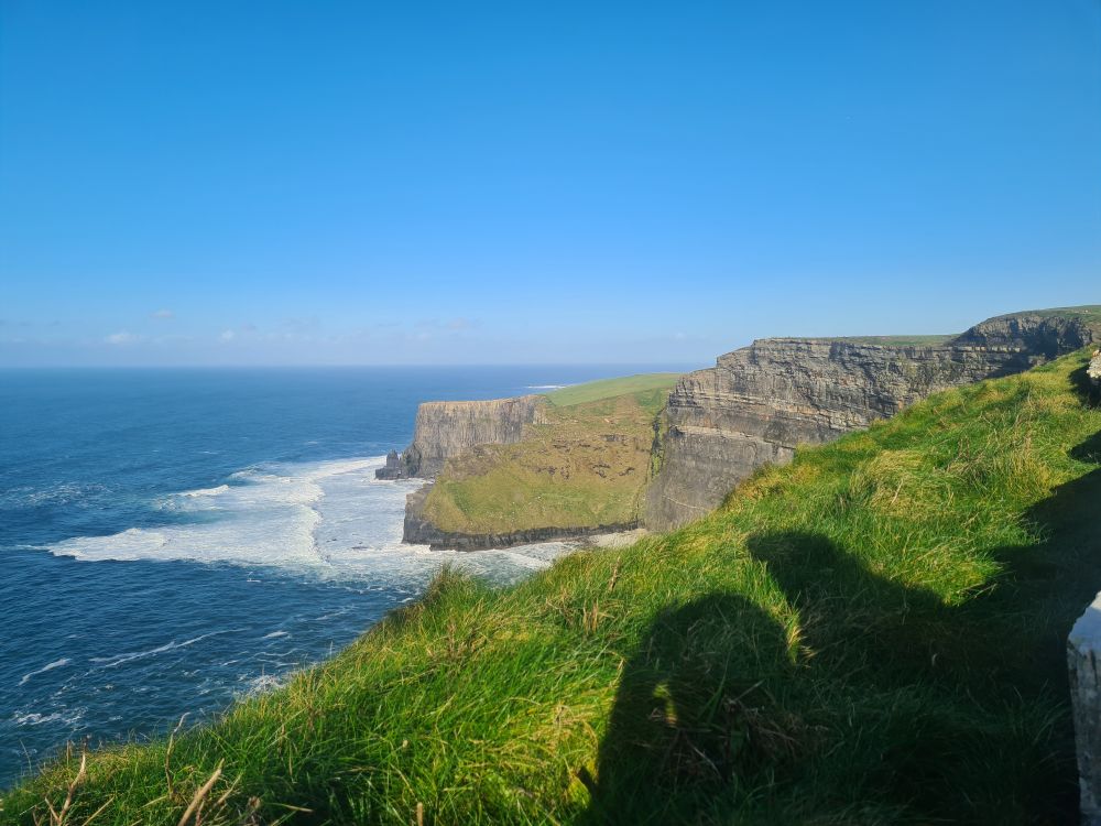 More cliffs image with bright blue sky and sloping cliffs. 