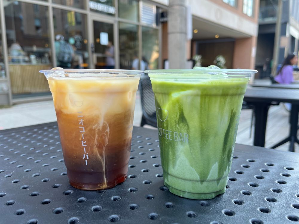 Two iced drinks, on the left a coffee and on the right a matcha latte. 