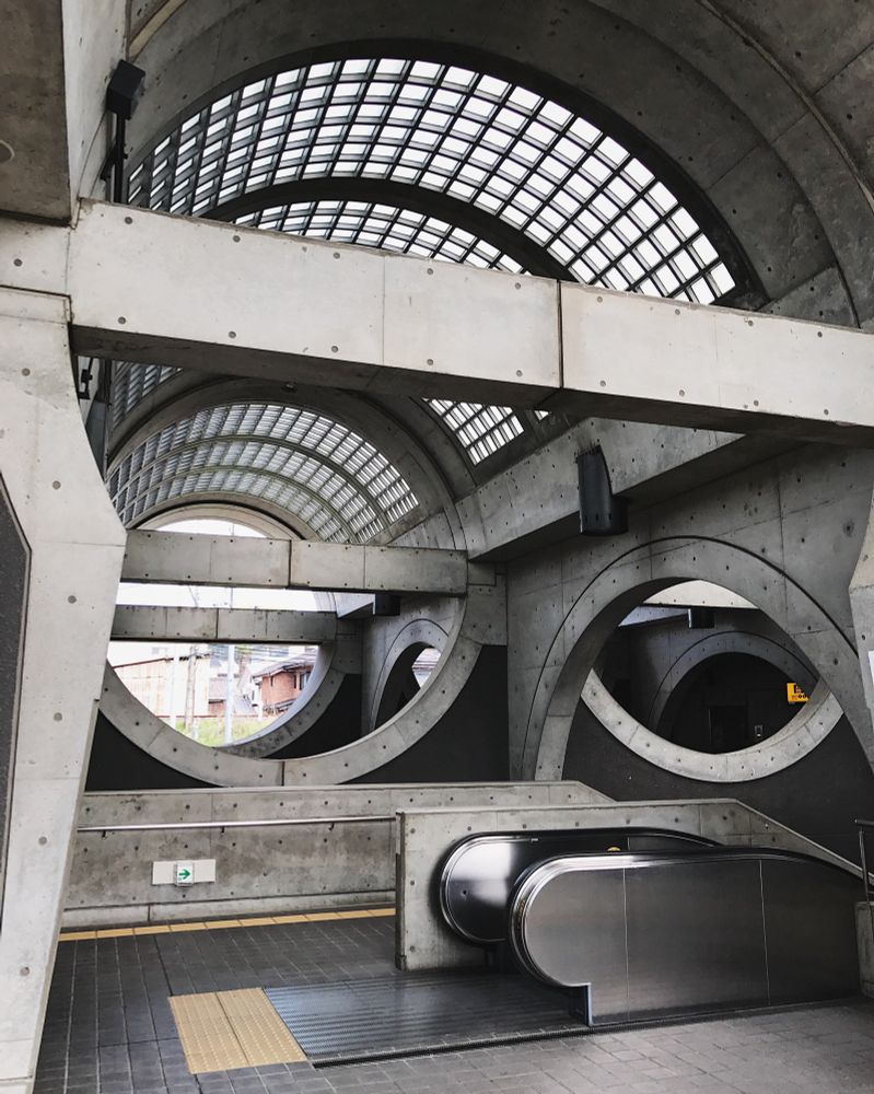 Uji Station, Japan. Circular shaped concrete building with panelled skylight and an escalator. 