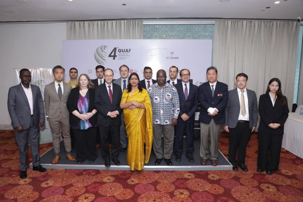 Group of GUAF participants posing in front of a conference banner