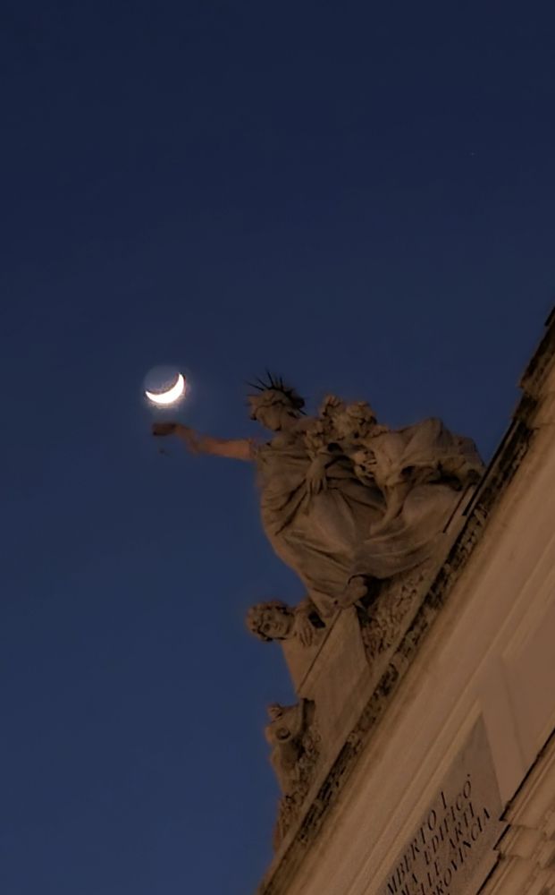 Foto di spicchio di luna sopra Palazzo delle Esposizioni a Roma.