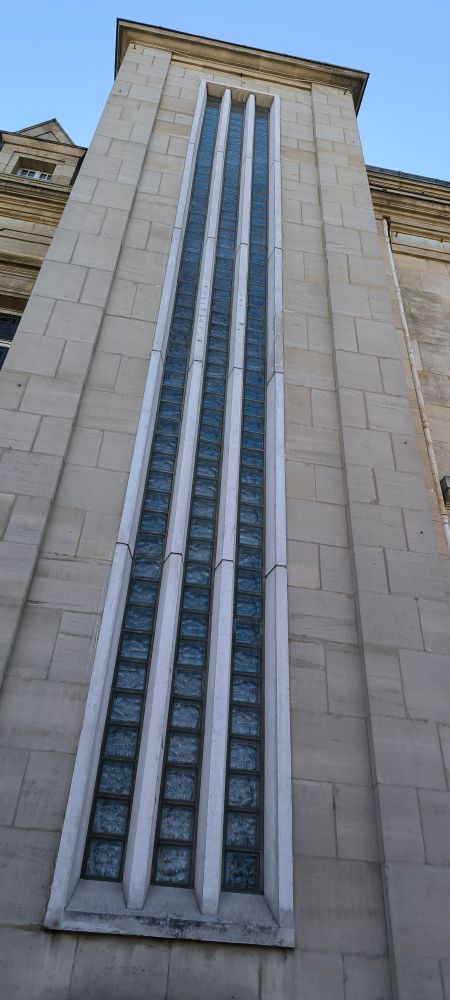 Picture of a long window on saint denis town hall with brutalist rods on the front