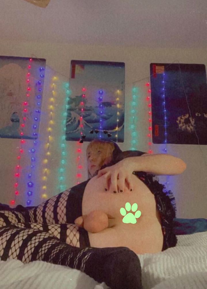 Pandora is laid on her side, presenting her ass, with her hand grabbing her ass. her ass is censored by a paw emoji. She is wearing striped fishnets and a miniskirt. 