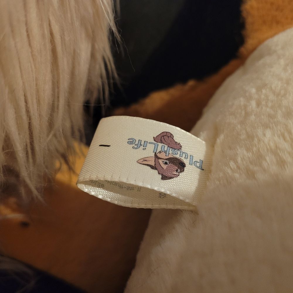 The tag of the plush shows the PlushLife logo and the number 1.