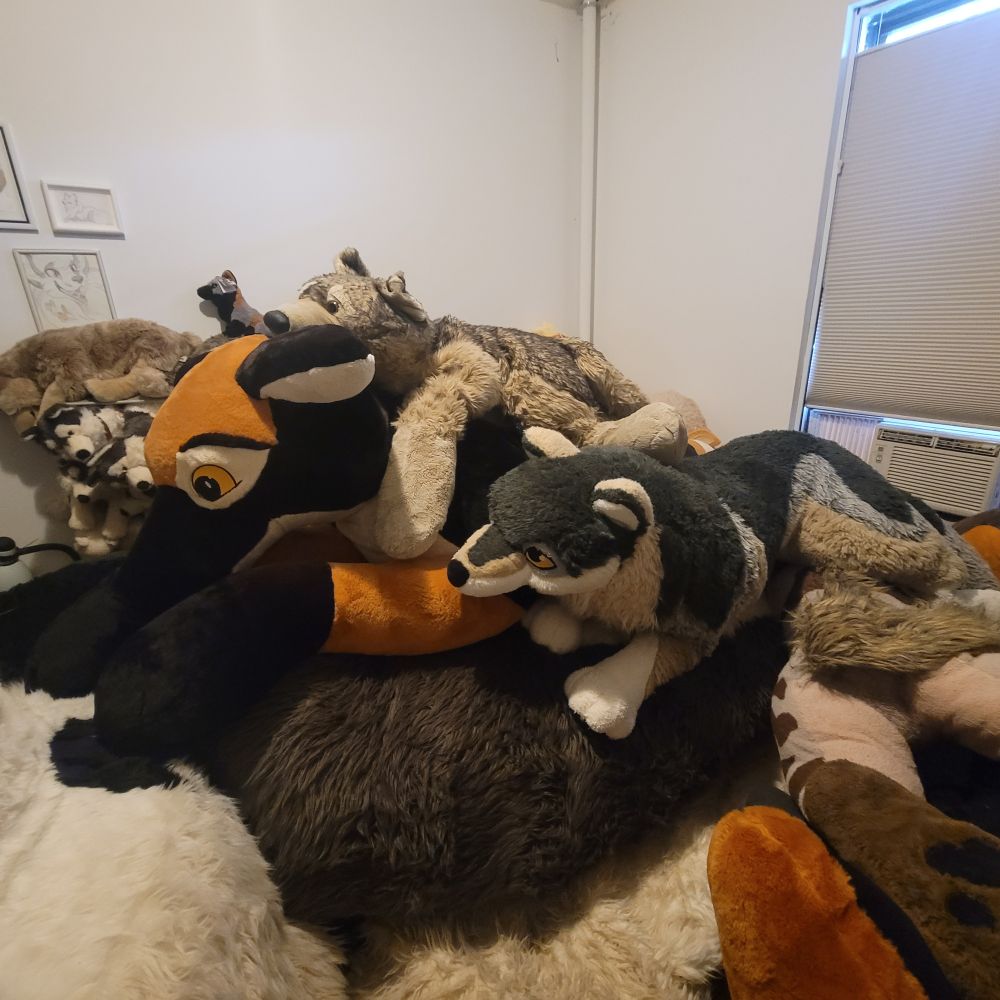The giant PlushLife german shepherd plush lies next to a 4 foot long JAAG Giant plush and a 6 foot long PlushLife wolf in the same room. (Both are much smaller.)