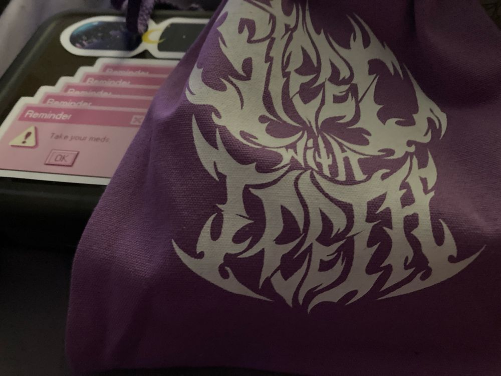 Light purple drawstring bag with a heavy metal style logo reading “Steel With Teeth”