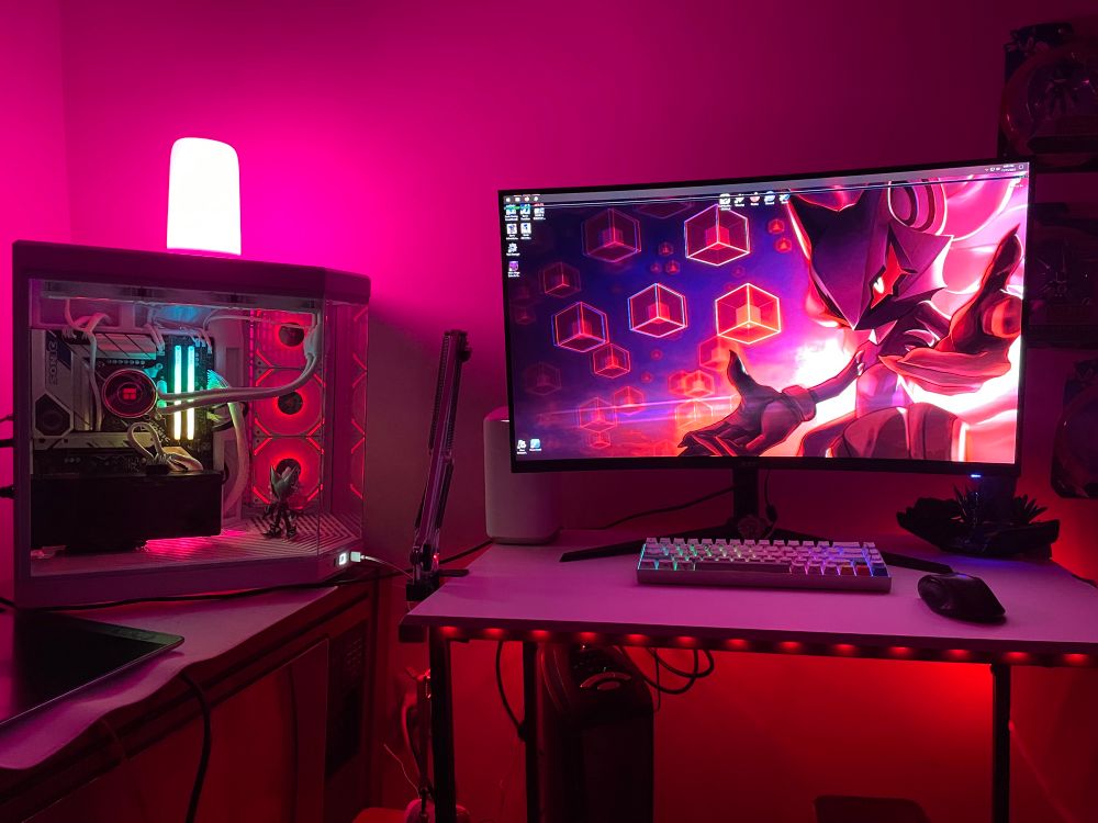 Photo of my desk setup including monitor and pc (bathed in red and pink rgb)