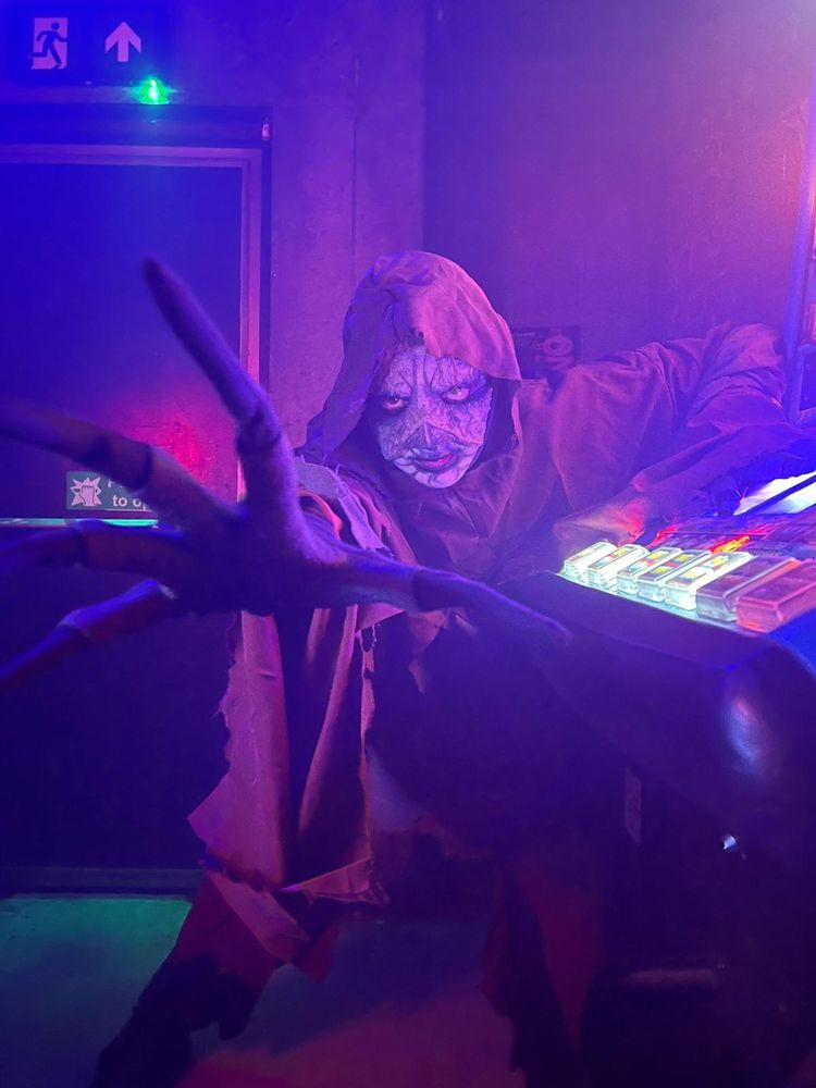 Hooded demonic/undead creature with unnaturally long fingers reaching towards the camera.