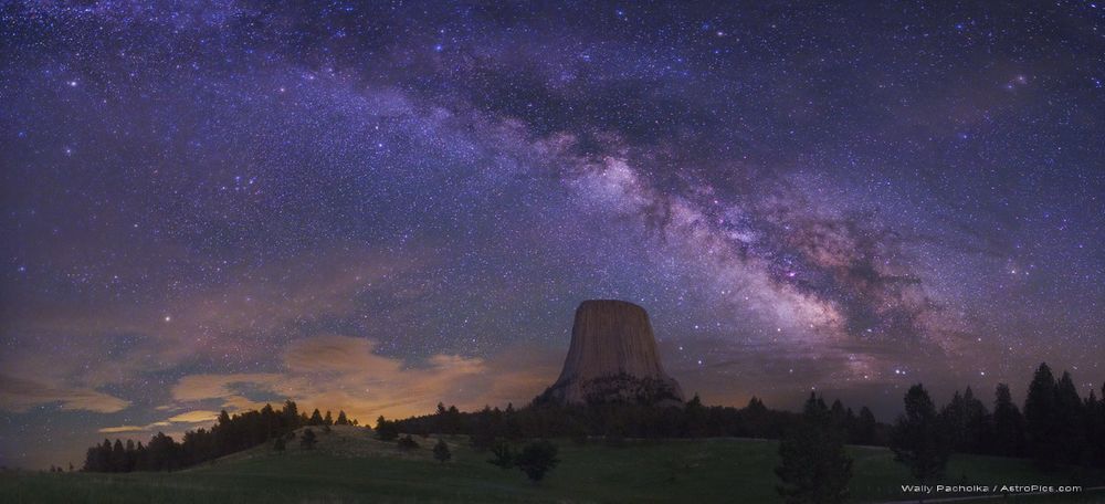 Was Devils Tower once an explosive volcano? Famous for its appearance in films such as Close Encounters, the origin of Devil's Tower in Wyoming, USA is still debated, with a leading hypothesis holding that it is a hardened lava plume that probably never reached the surface to become a volcano.  The lighter rock that once surrounded the dense volcanic neck has now eroded away, leaving the dramatic tower. High above, the central band of the Milky Way galaxy arches across the sky. Many notable sky objects are visible, including dark strands of the Pipe Nebula and the reddish Lagoon Nebula to the tower's right. Green grass and trees line the moonlit foreground, while clouds appear near the horizon to the tower's left. Unlike many other international landmarks, mountaineers are permitted to climb Devils Tower.    Note: An APOD editor will review great space images this Saturday night at Ft. Wilkins, Michigan.