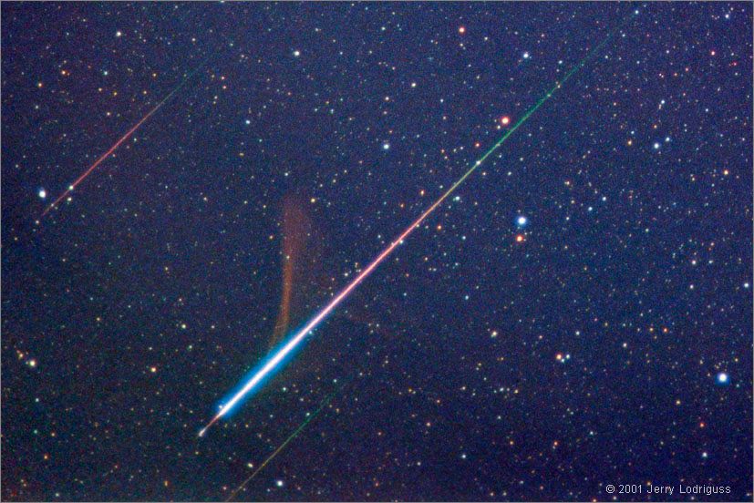 Returning from orbit, space shuttles enter the atmosphere at about 8 kilometers per second as friction heats their protective ceramic tiles to over 1,400 degrees Celsius. By contrast, the bits of comet dust which became the Leonid meteors seen on November 18, were moving at 70 kilometers per second, completely vaporizing at altitudes of around 100 kilometers. In this single 5 minute time exposure, three Leonid meteors are shooting through skies above Spruce Knob, West Virginia, USA.  Background stars are near the constellation Orion. The brightest meteor, a fireball, dramatically changes colors along its path and leaves a smokey persistant trail drifting in high-altitude winds. From that extremely dark site, at an elevation of 1,200 meters, astrophotographer Jerry Lodriguss reports, "We observed a [zenithal hourly rate] of about 3,600 at 10:30 UT and very high rates from 9:30 UT until well into the start of astronomical twilight at 10:50 UT. It was quite a spectacular storm, with bolides going off like flashbulbs, green and red fireballs and other fainter Leonids in all parts of the sky."