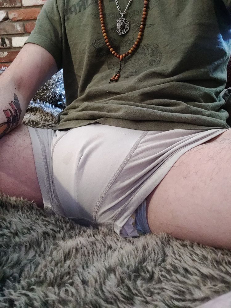 Charlie's sitting in white boxer briefs stretched over his diaper. The diaper is peeking out through the leg hole