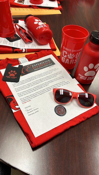 Close up of a school swag collection for new staff, including a letter from the principal, a school T-shirt, sunglasses and a water bottle.