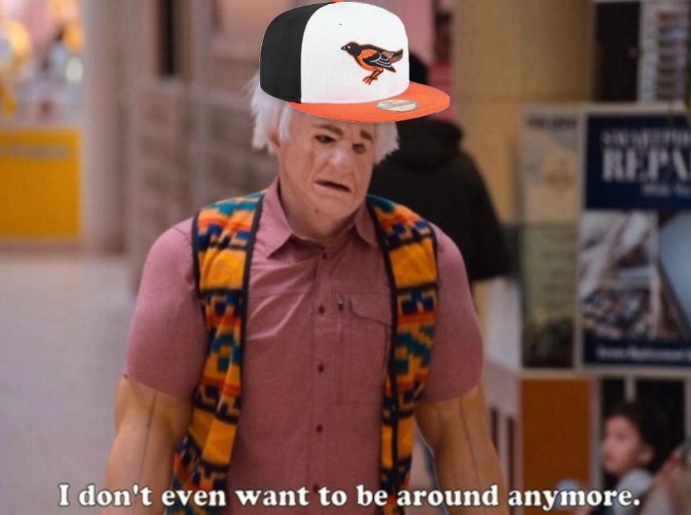 i think you should leave character Karl Havoc- tim robinson in a weird rubber suit, button up shirt, and vest.  he is wearing an old man mask that looks terrible. the character is saying “i don’t even want to be around anymore”. an orioles hat has been added to karl havoc’s head