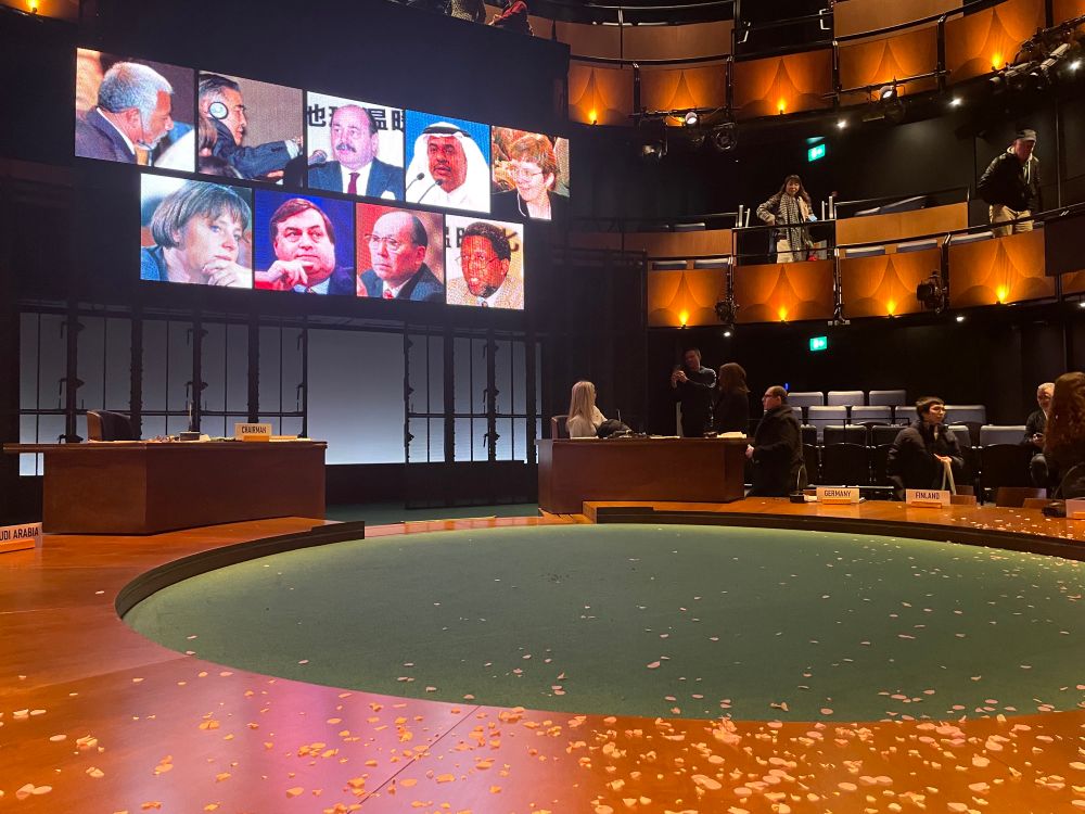 Photos of the original Kyoto COP negotiators as a backdrop to the stage, at the play Kyoto. Photos include John Prescott and Dr Angela Merkel. 