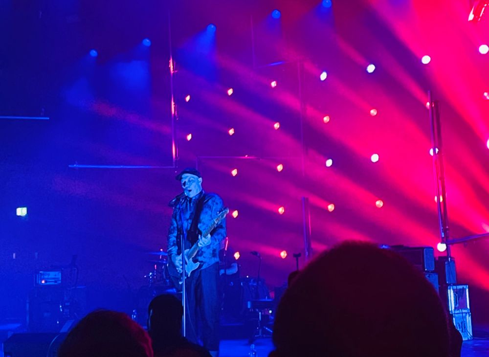 Stuart Braithwaite from Mogwai on stage with pink lights 