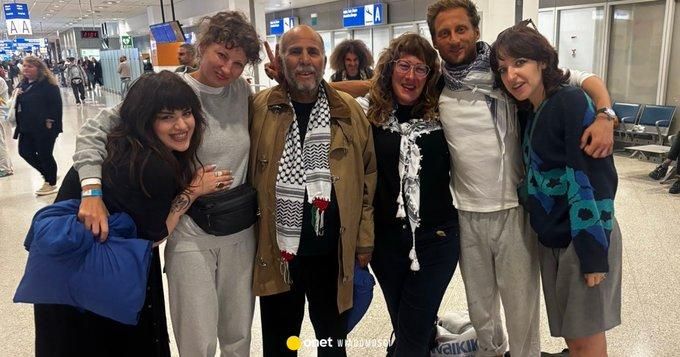 Sześć obejmujących się i uśmiechniętych osób na lotnisku