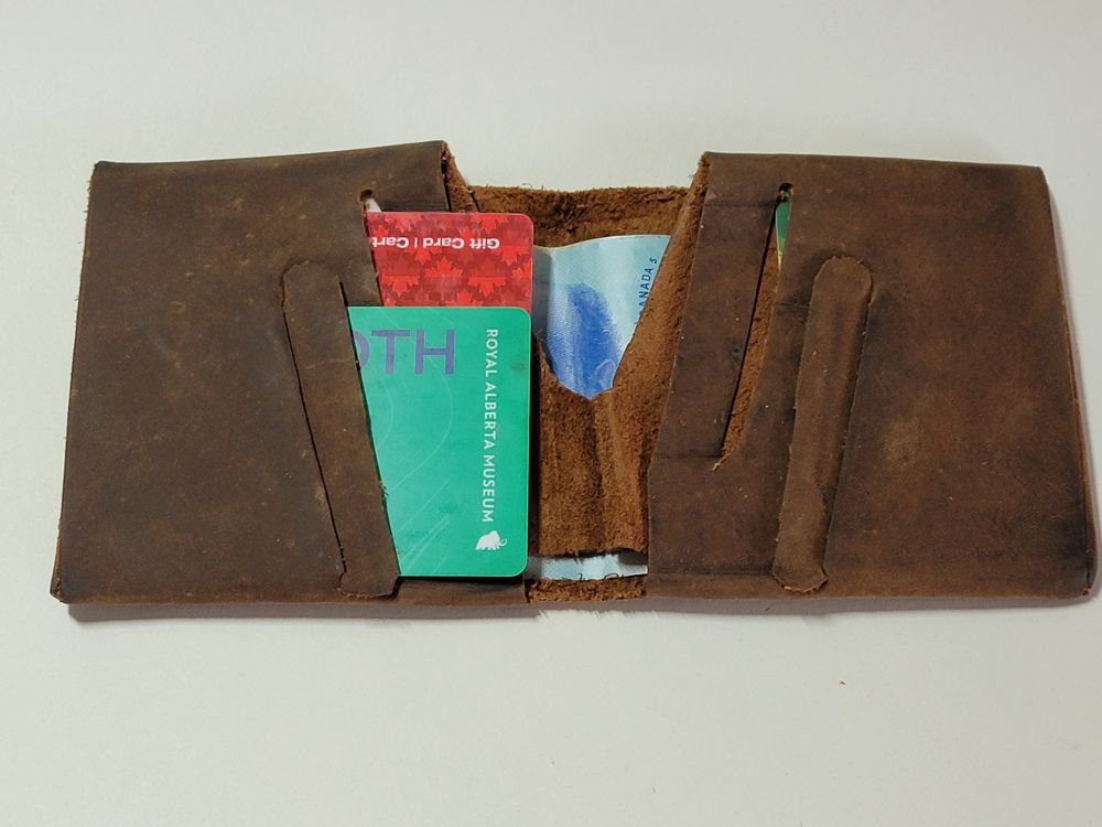 An overall view of the wallets interior with cards removed on one side to better show the card slots.