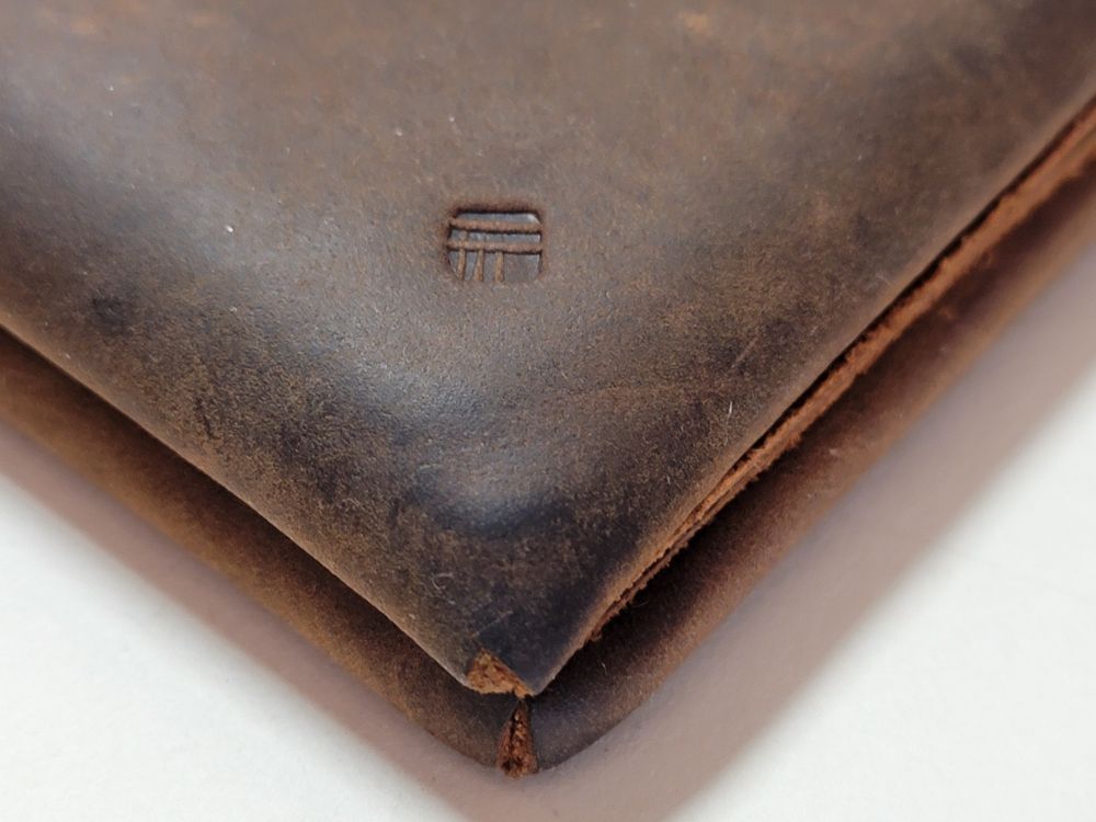 Close up of the exterior of the wallet, showing the maker's mark and corners.