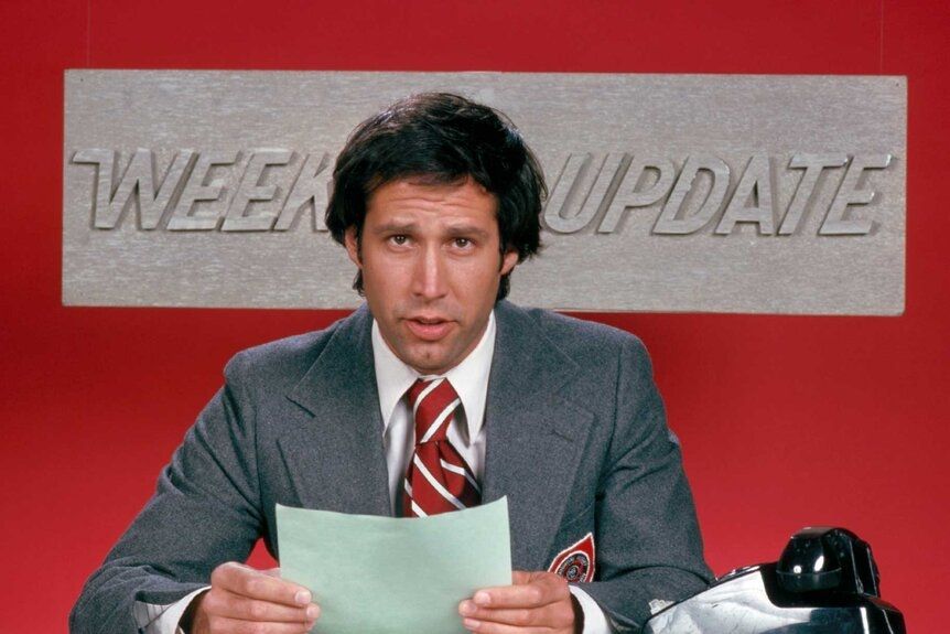 Chevy Chase at The Weekend Update desk for Saturday Night Live