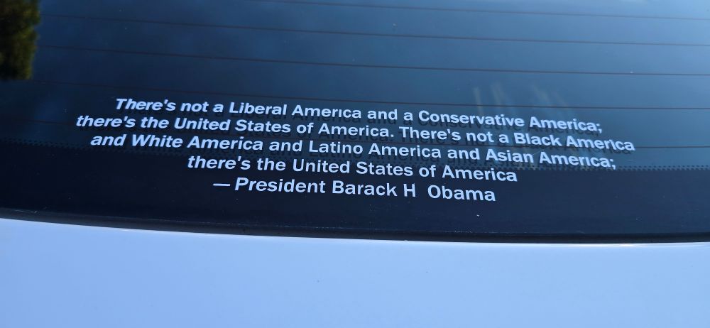 White vinyl lettering on the lower back windshield that is a quote that reads there is not a liberal in America and a conservative America there is the United States of America. There is not a Black America and White America and Latino America and Hispanic america. There's the United States of america. President Obama