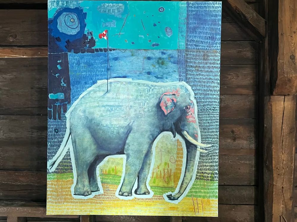 image of elephant in painted form with a small Canadian flag on a pole planted in its back - blue and textual background 