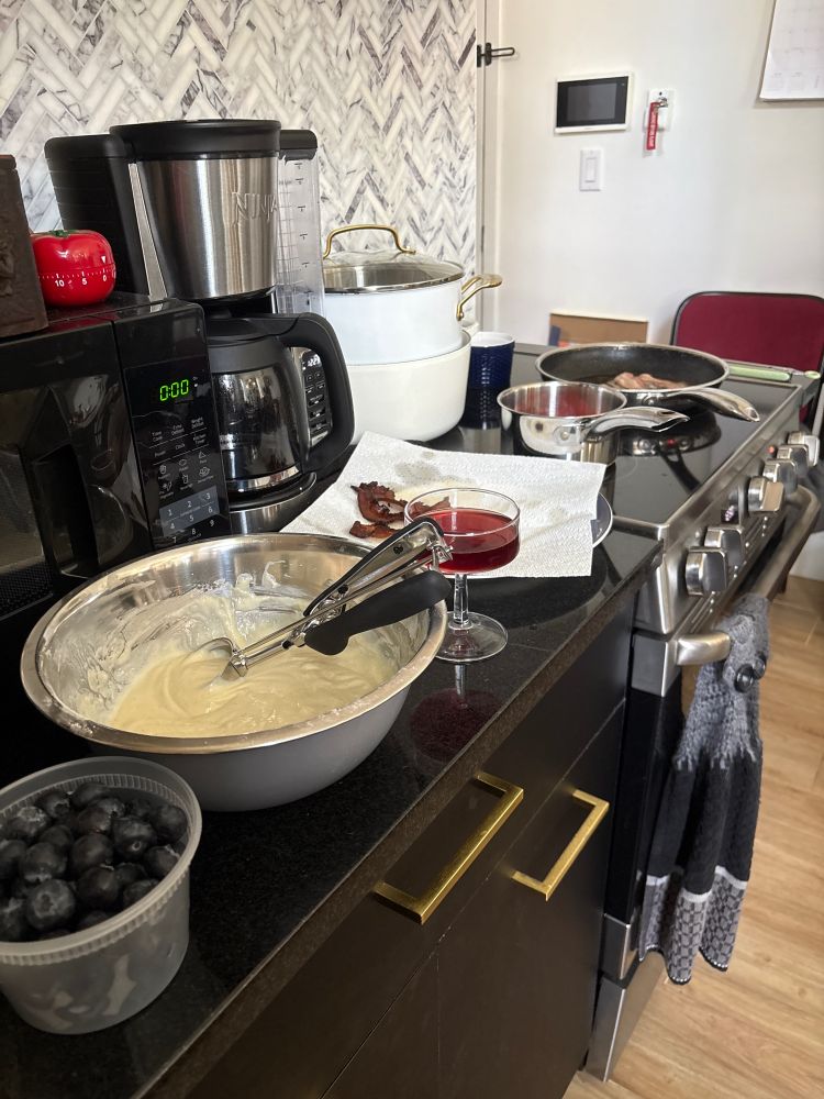 Ingredients for a family breakfast of pancakes and bacon with a glass of chilled red wine. 