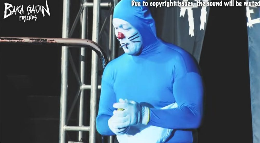 minoru suzuki dressed as doraemon with a cigarette in his mouth at baka gaijin 