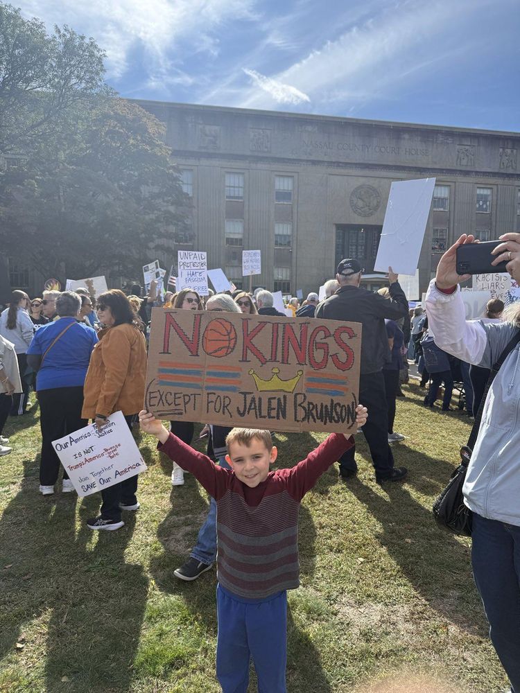 Boy holding sign saying "No Kings (Except for Jalen Brunson)"
