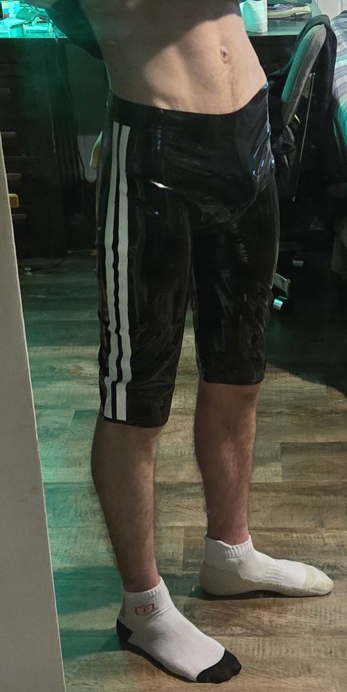 Twink in rubber latex shorts with socks on