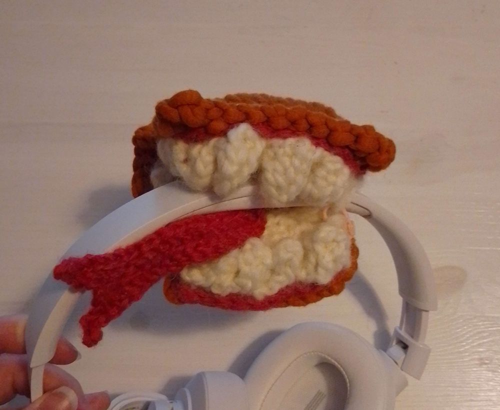 knitted + crocheted book shaped mimic wrapped around my headphones headband to stop it from digging into my skull.