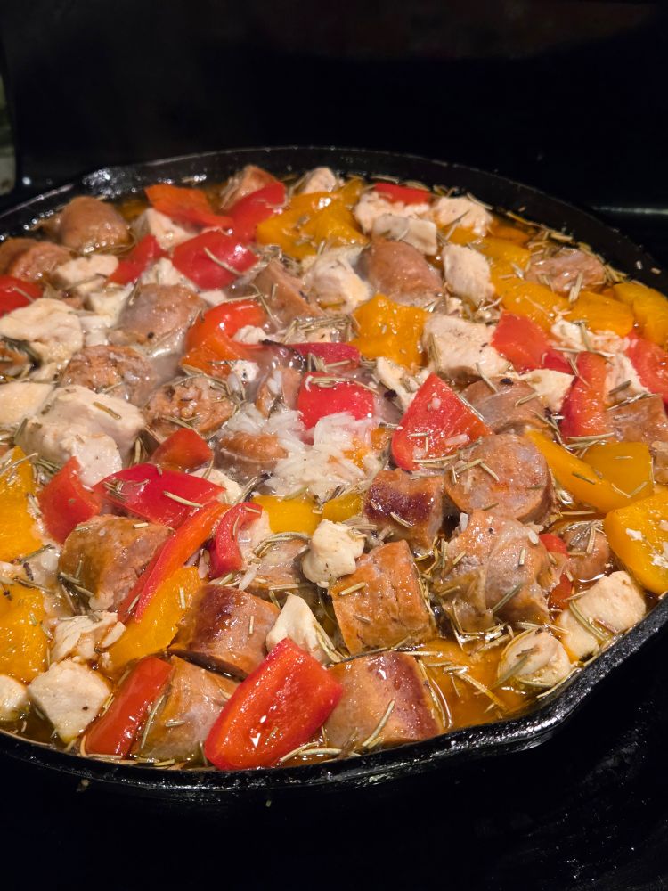 Paella almost completely filling a cast iron skillet 