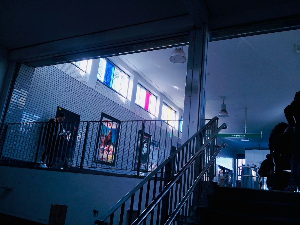 View from the platform stairs to the entrance hall with light streaming in from the left through the stained windows.